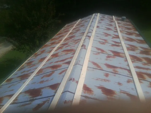 Rusted metal roof panels with new wood purlins before replacement — Storm Damage Roof Repair in Pond Eddy by Roofing Brothers