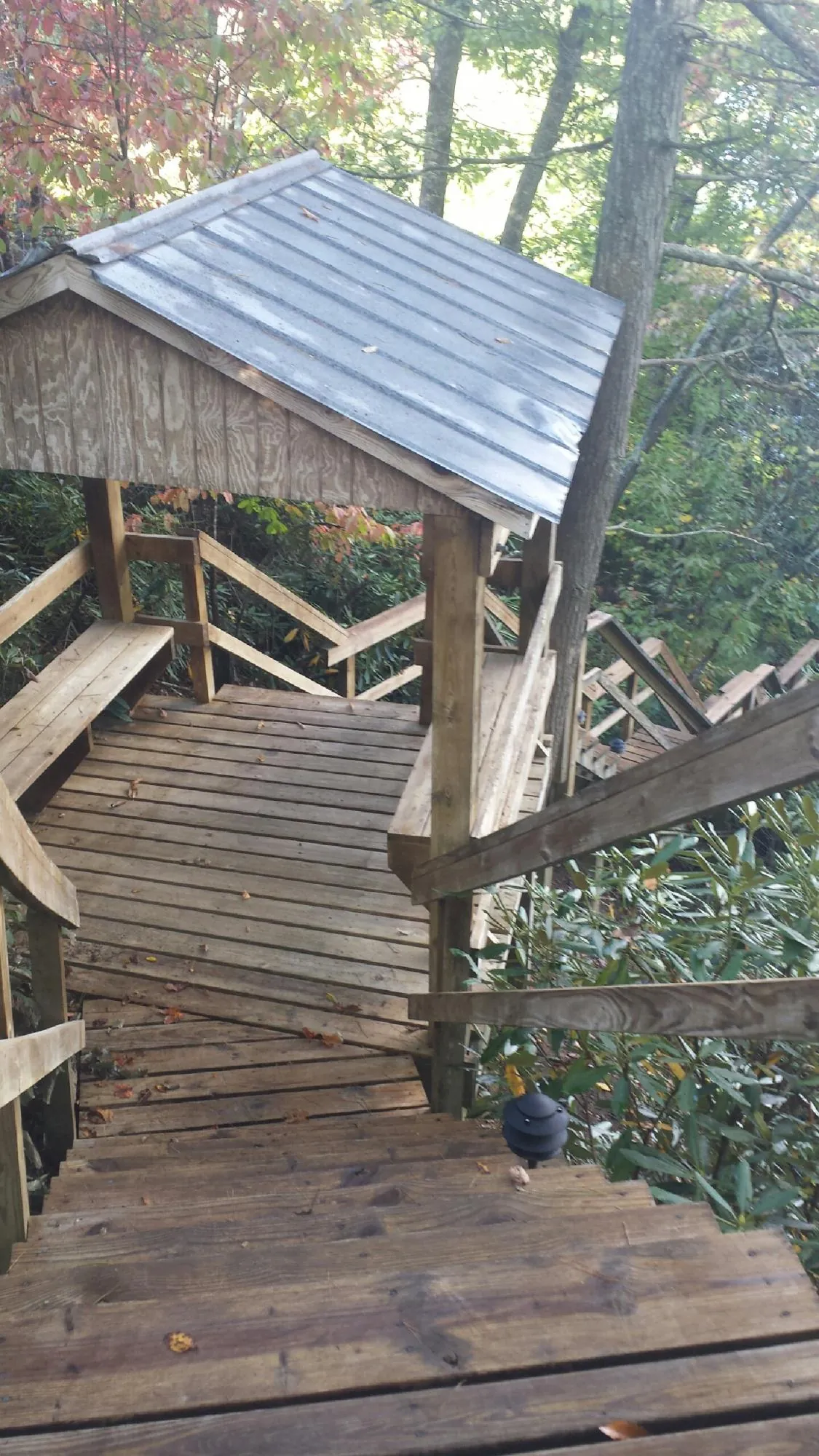 Metal roofed shelter over wooden steps on a wooded walkway — Skylight Repair & Installation work by our crew in Pond Eddy