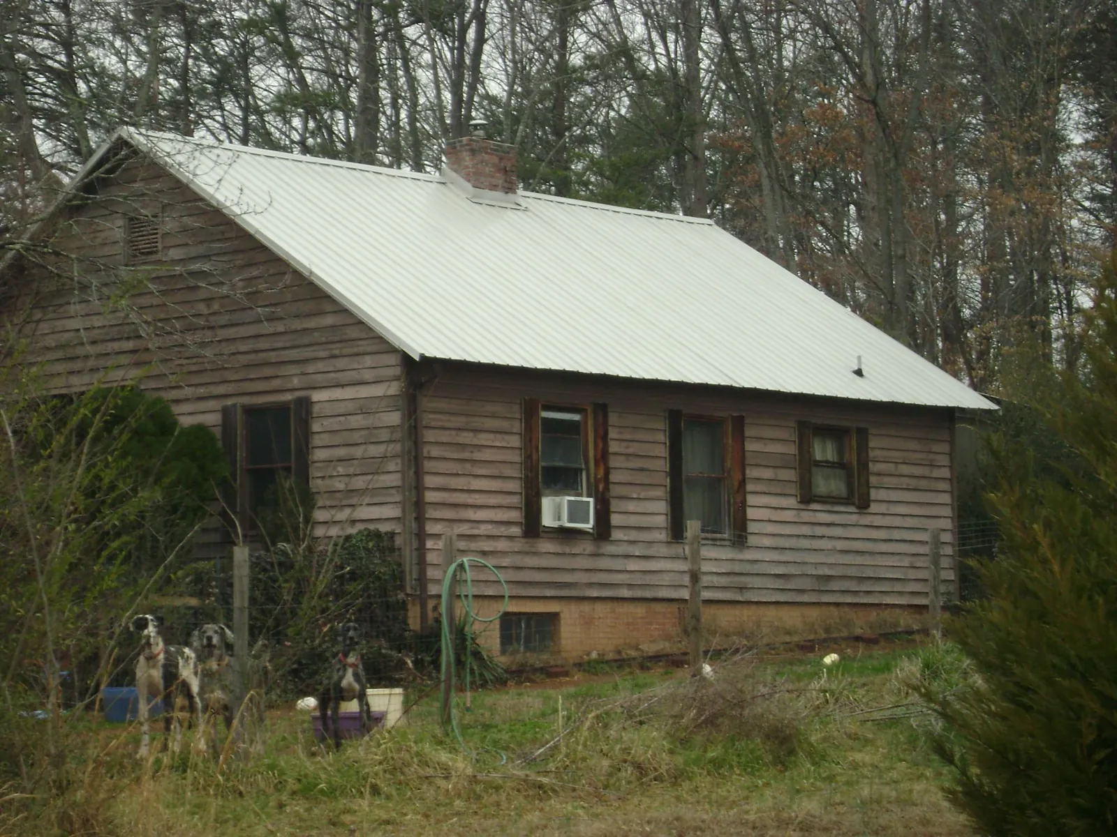 White metal roof on an old wood sided farmhouse, from a Metal Roof Installation job in Pond Eddy